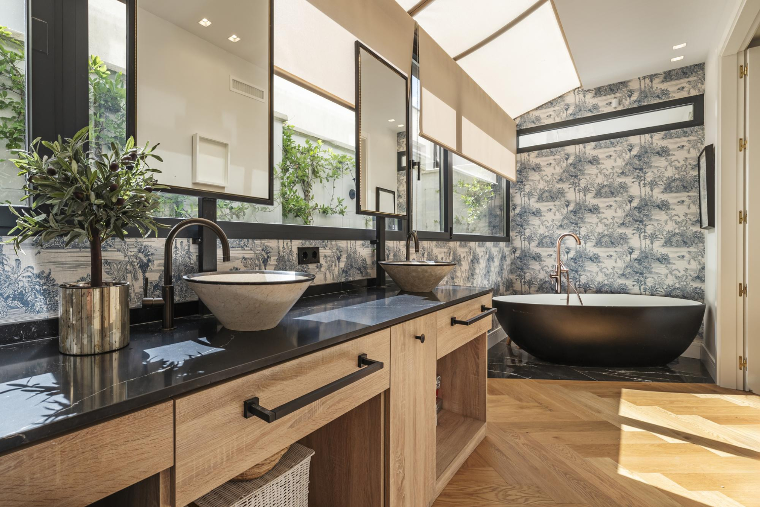 Modern bathroom with double sinks, a black soaking tub, large windows, and natural wood accents.